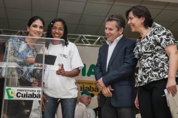 Ministra Tereza Campello e o prefeito de Cuiabá, Mauro Mendes, acompanham a assinatura da carteira profissional da Adriele Correia, operadora de caixa –