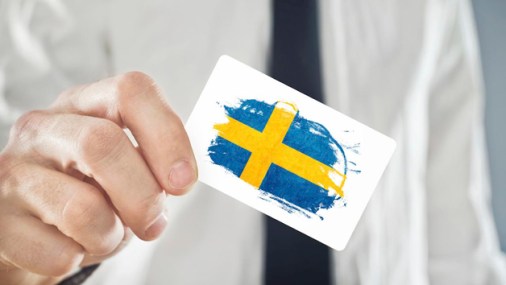 Swedish Businessman holding business card with Sweden Flag
